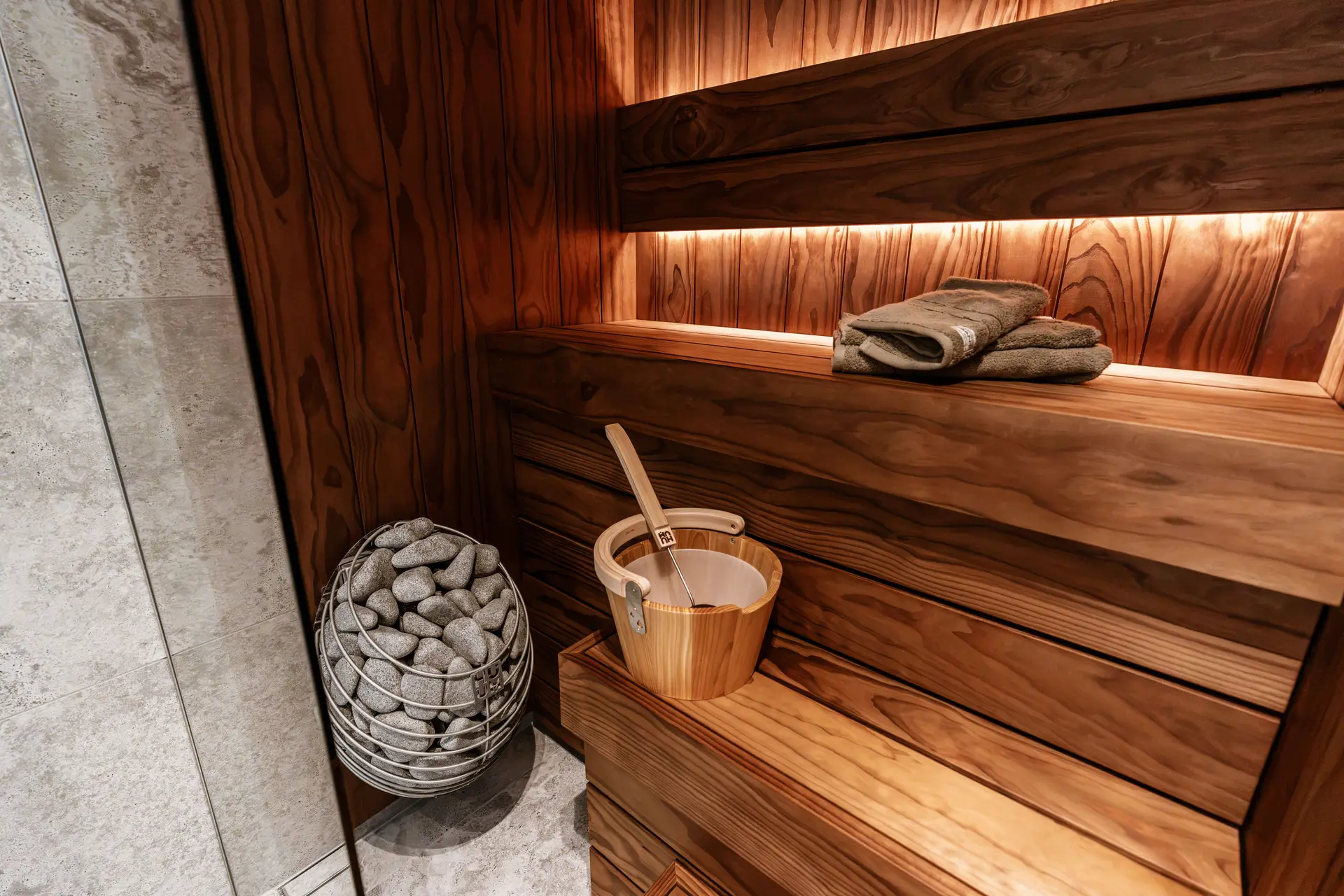 Scandinavian-inspired indoor sauna showcasing precise natural timber joints and stone