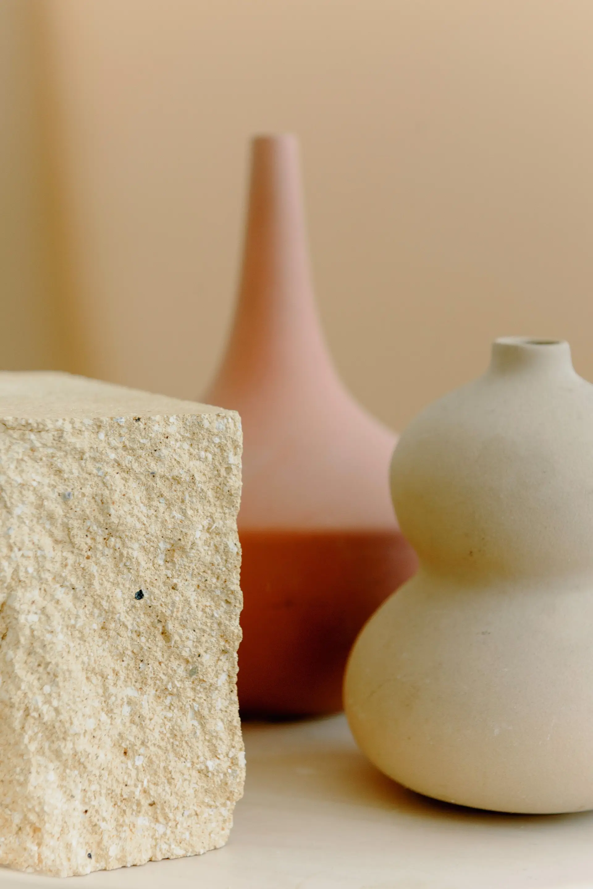 Sculptural stone form and ceramic vessels in natural architectural light